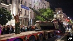 Members of the Wagner Group military company load their tank onto a truck on a street in Rostov-on-Don, Russia, June 24, 2023, prior to leaving an area at the headquarters of the Southern Military District.
