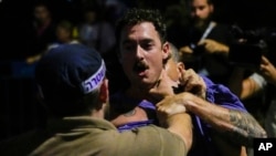 Police forcibly detain an Israeli protesting against plans by Prime Minister Benjamin Netanyahu's government to overhaul the judicial system, in Tel Aviv, July 20, 2023.
