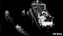 This still image taken from surveillance video from a U.S. Navy Boeing P-8 Poseidon shows three Iranian Revolutionary Guard fast-attack vessels near a commercial ship in the Strait of Hormuz, June 4, 2023. (U.S. Navy via AP)