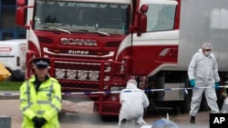 FILE - Forensic police officers attend the scene where a truck was found with a large number of dead bodies, in Grays, England, Oct. 23, 2019. 