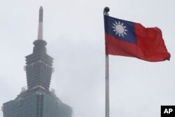 Bendera nasional Taiwan berkibar di dekat gedung Taipei 101 di National Dr. Sun Yat-Sen Memorial Hall di Taipei, Taiwan, pada 7 Mei 2023. (Foto: AP)