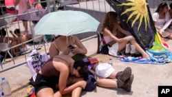 Taylor Swift fans wait for the doors of Nilton Santos Olympic stadium to open for Swift's Eras Tour concert amid a heat wave in Rio de Janeiro, Brazil, Nov. 18, 2023. The singer wound up postponing her Saturday concert after a 23-year-old fan died during her Friday show. 