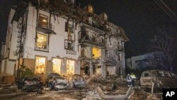 FILE - In this photo provided by the Ukrainian Emergency Service, firefighters examine the site of Russia's missile attack that hit a hotel in Kharkiv, Ukraine, late Jan. 10, 2024. (Ukrainian Emergency Service via AP)