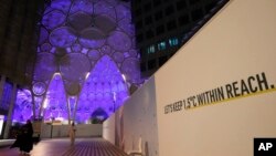 Sebuah tulisan dipasang dekat Kubah Wasi di Expo City berbunyi "Mari Jaga suhu 1,5 derajat Celsius tetap dalam jangkauan',: di KTT Iklim PBB, di Dubai UEA, 1 Desember 2023. (Foto: Peter Dejong/AP Phofto)