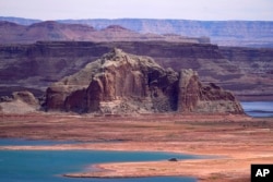 FILE - Low water levels at Wahweap Bay at Lake Powell along the Upper Colorado River Basin are seen, June 9, 2021, at the Utah and Arizona border at Wahweap, Arizona.