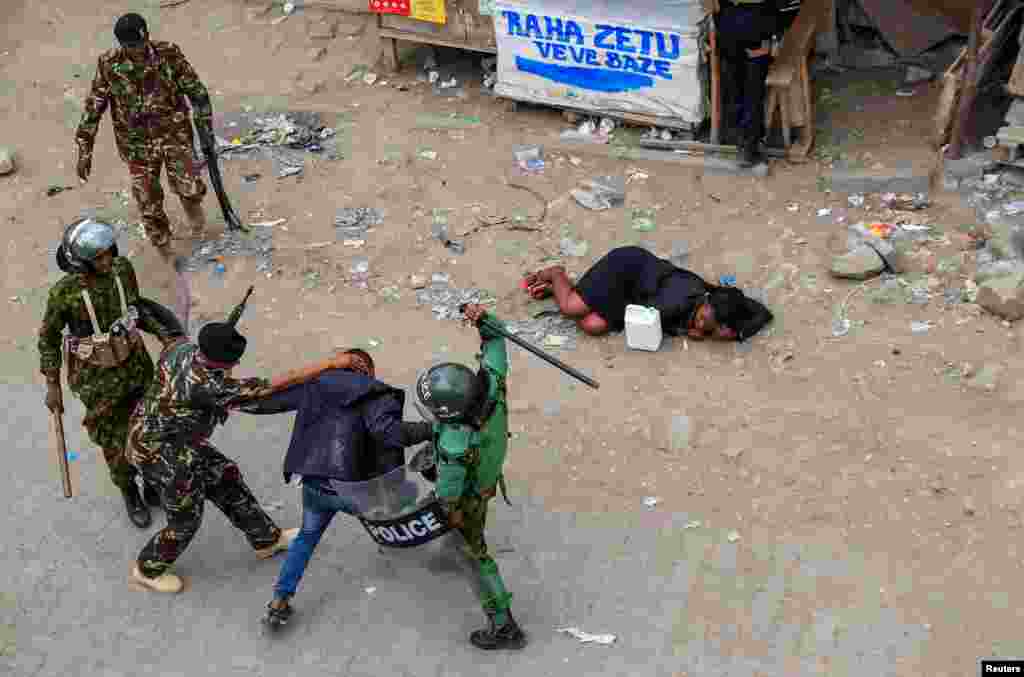 Riot police accost a supporter of Kenya's opposition leader Raila Odinga during an anti-government protest against the imposition of tax hikes by the government, in Mlolongo settlement of Machakos county, July 12, 2023.