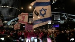 Protesters block a street adjacent to Hostages Square holding signs against the government as they demand the release of the hostages taken by Hamas militants into the Gaza Strip in Tel Aviv, Israel, Jan. 13, 2024.