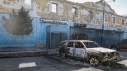 Yon machin ki boule devan Penitansye Nasyonal la anba lavil Potoprens, Ayiti, 3 Mas, 2024. 