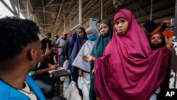 Somali refugees queue to receive food in Dadaab refugee camp in northern Kenya, Thursday, July 13, 2023.