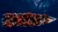 FILE - Migrants from Eritrea, Libya and Sudan sail a wooden boat before being assisted by aid workers of the Spanish NGO Open Arms, in the Mediterranean sea, about 30 miles north of Libya, June 17, 2023. 