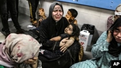 Wounded Palestinians sit in al-Shifa Hospital in Gaza City, central Gaza Strip, after arriving from al-Ahli Hospital following an explosion there, Oct. 17, 2023. (AP Photo/Abed Khaled, File)