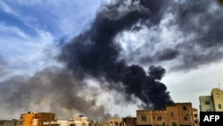 Asap tampak mengepul dari gudang penyimpanan kayu di selatan Kota Khartoum di tengah pertempuran yang berlangsung di Sudan pada 7 Juni 2023. (Foto: AFP)