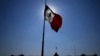 FILE - A Mexican flag waves in front of The National Palace, the office of the president, in Mexico City's main square, the Zocalo, at sunrise, April 24, 2023. 