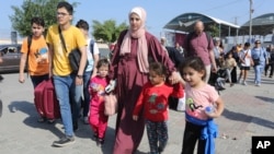 Palestinians cross to the Egyptian side of the border crossing with the Gaza Strip in Rafah, Nov. 1, 2023.