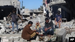 ជនជាតិ​ប៉ាឡេស្ទីន​ចម្អិន​អាហារ​នៅ​ខាងមុខ​អគារ​បាក់បែក​អំឡុង​បទឈប់បាញ់រវាង​ហាម៉ាស់​និង​អ៊ីស្រាអែលកាលពីថ្ងៃទី​២៩ វិច្ឆិកា ឆ្នាំ២០២៣។