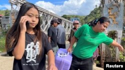 People who fled Myanmar carry their belongings across a bridge that connects Myanmar and India at the border village of Zokhawthar, Champhai district, in India's northeastern state of Mizoram, Nov. 15, 2023.