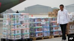 Indonesian President Joko Widodo walks by relief supplies during the inspection of aid for Palestinians in Gaza, before its departure at Halim Perdanakusuma air base in Jakarta, Indonesia, Nov. 4, 2023. 