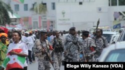 Désiré Uwamahoro (Ari hagati) mw'ibarabara ryo ku murwa mukuru w'ubutunzi Bujumbura. Ino foyo yaafashwe akijejwe igisata kijejwe kurwanya imigumuko. Ni ifoto yafatiwe mu myiyerekano yo kwiyamiriza manda ya gatatu y'Umuhisi Petero Nkurunziza.