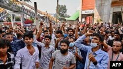 Garment workers block roads as they take part in a protest in Dhaka, Nov. 1, 2023. Thousands of Bangladeshi garment workers barricaded roads, demanding fair wages for clothing they make for major Western brands.

