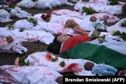 Aktivis yang mewakili korban konflik Israel-Hamas, tergeletak di tanah di depan Gedung Putih saat unjuk rasa mendukung warga Palestina di Washington, DC, pada 2 Desember 2023. (Foto: AFP)