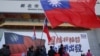 Sejumlah orang mengibarkan bendera Taiwan selama kampanye partai oposisi utama Kuomintang (KMT) menjelang pemilihan presiden, di New Taipei City pada 12 Januari 2024. (Foto: AFP)