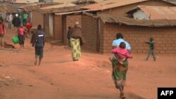 FILE - Refugees from various nationalities walk through Dzaleka refugee camp in Dowa District Central region of Malawi on June 20, 2018.