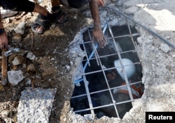 Palestinians search for casualties at the site of an Israeli strike on a house, amid the ongoing conflict between Israel and Palestinian Islamist group Hamas, in Khan Younis in the southern Gaza Strip on November 6, 2023. (REUTERS/Ibraheem Abu Mustafa)