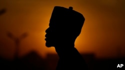 FILE - An atheist stands against the sunset sky in Kano, Nigeria, July 14, 2023. 