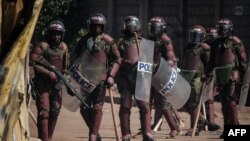 FILE - Kenyan Police officers watch protesters blocking a street during a rally called by opposition leader Raila Odinga, in Kibera, Nairobi, March 27, 2023. A court ruled on Jan. 26, 2024 against a government's plan to deploy police officers to Haiti.