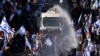 Israeli police use a water cannon to disperse demonstrators blocking a road during a protest against plans by Prime Minister Benjamin Netanyahu's government to overhaul the judicial system, in Jerusalem, July 24, 2023.