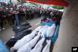 Palestinians pray for the relatives killed in the Israeli bombardments of the Gaza Strip in front of the morgue of the Al Aqsa Hospital in Deir al Balah, Gaza Strip, March 7, 2024.