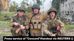Le fondateur du groupe Wagner Evguéni Prigojine pose avec les mercenaires "Biber" et "Dolik" à Bakhmut, Ukraine, dans cette image fixe tirée d'une vidéo publiée le 25 mai 2023.