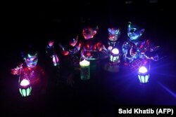 Anak-anak Palestina membawa lentera tradisional "fanous" di Rafah, di selatan Jalur Gaza, pada malam bulan suci Ramadan pada 10 Maret 2024. (Foto: AFP/Said Khatib)