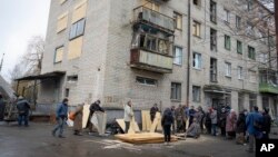 Residents use plywood to replace windows in their homes shattered during a night Russian rocket attack in Sloviansk, Ukraine, Jan. 27, 2024.