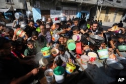 Palestinians crowded together as they wait for food distribution in Rafah, southern Gaza Strip, Nov. 8, 2023.