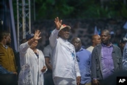 Democratic Republic of the Congo President Felix Tshisekedi, center, flanked by his wife, Denise Nyakeru, greets supporters at a rally in Goma, Eastern Congo, Dec. 10, 2023.