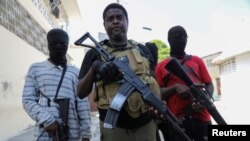 지난 5일 아이티 수도 포르토프랭스에서 'G9' 갱단 연합 두목이자 전직 경찰인 지미 셰리지에(가운데) 기자회견 직후 갱 멤버들이 곁에 서 있다. (자료사진)