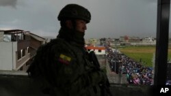 A soldier stands guard as supporters of presidential candidate Luisa Gonzalez, of the Citizen's Revolutionary Movement, attend a campaign rally in Quito, Ecuador, Oct. 11, 2023. 