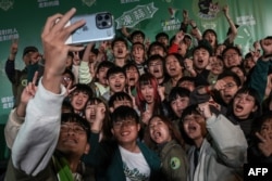 Supporters of Taiwanese Vice President and ruling Democratic Progressive Party presidential candidate Lai Ching-te pose for a group selfie in Taipei, Taiwan, after Lai won the presidential election, Jan. 13, 2024.