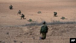 Israeli soldiers take positions near Kibbutz Kfar Azza, Oct. 10, 2023.