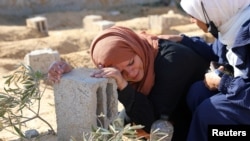 Seorang perempuan Palestina menangis di atas makam putranya yang terbunuh dalam serangan udara Israel, di Khan Younis, Jalur Gaza, pada 18 Januari 2024. (Foto: Reuters/Arafat Barbakh)