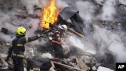 Rescuers work the scene of a building damaged by Russian rocket in Kharkiv, Ukraine, Jan. 23, 2024. On the same day, U.S. lawmakers said a deal on border security in return for Republican votes to send nearly $60 billion in aid to Ukraine is nearing completion.