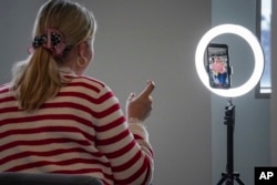 Gen Z kerap disebut sebagai digital native, karena lahir dan tumbuh di era digital. Dalam foto ini, Olivia Empson, reporter The News Movement (TNM), kanal media sosial berita bagi konsumen Gen Z, membuat konten video menggunakan telepon genggamnya. (AP/Bebeto Matthews)