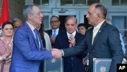 Swiss Foreign Minister Ignazio Cassis, second left, with Pakistan's disaster manager, Lieutenant General Inam Haider Malik, right, near Islamabad, Pakistan, June 8, 2023.