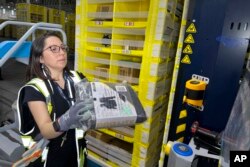 FILE - A worker moves a package at an Amazon same-day delivery shipping center in Woodland Park, New Jersey, Dec. 18, 2023.