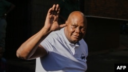 L'ancien législateur zimbabwéen et membre éminent du parti d'opposition Citizens Colaition for Change (CCC) Job Sikhala salue la presse et les sympathisants devant le tribunal de première instance de Harare, le 24 janvier 2024. (Photo par Jekesai NJIKIZANA / AFP)