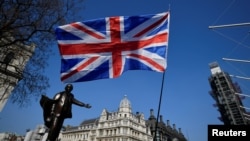 A British flag flutters in Parliament Square in London, March 29, 2019. A researcher in the British parliament was arrested in March 2023 on suspicion of spying for Beijing.