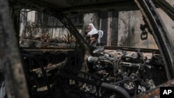 A Palestinian woman sits outside her torched home, days after it was set on fire by Jewish settlers, in the West Bank town of Turmus Ayya, June 24, 2023. 