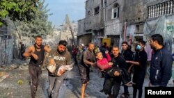 Wapalestina wakiwabeba watoto waliojeruhiwa kufuatia shambulizi la Israeli katika eneo la makazi, baada ya muda mfupi wa kusitishwa mapigano kati ya Hamas na Israel kumalizika huko Rafah, Kusini ya Ukanda wa Gaza.