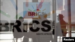 Delegasi Afrika Selatan duduk di belakang kaca dengan logo BRICS saat KTT BRICS diadakan di Johannesburg, Afrika Selatan, 23 Agustus 2023. (Foto: REUTERS/Alet Pretorius)